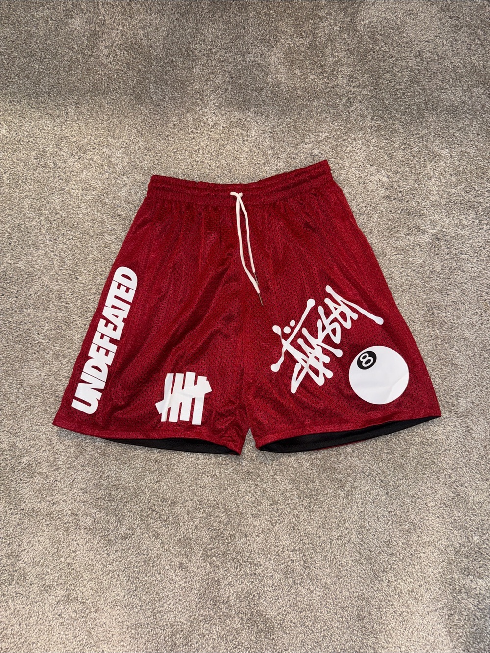 Undefeated Red Mesh Athletic Shorts with White Logo Accents